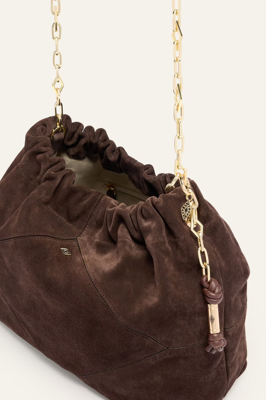Brown suede handbag with a gold chain strap on a white background
