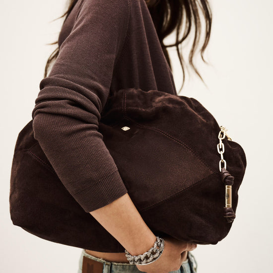 Person holding a brown bag with a neutral background