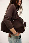 Person holding a brown bag with a neutral background