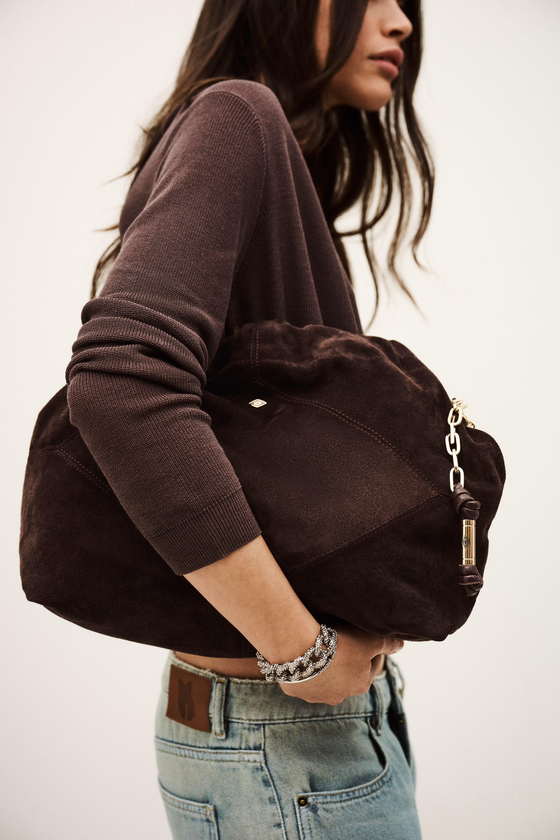 Person holding a brown bag with a neutral background