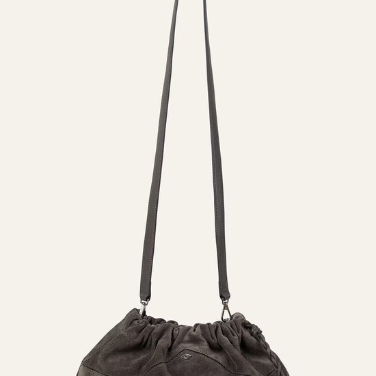 Dark gray shoulder bag with a long strap on a light beige background from ba&sh