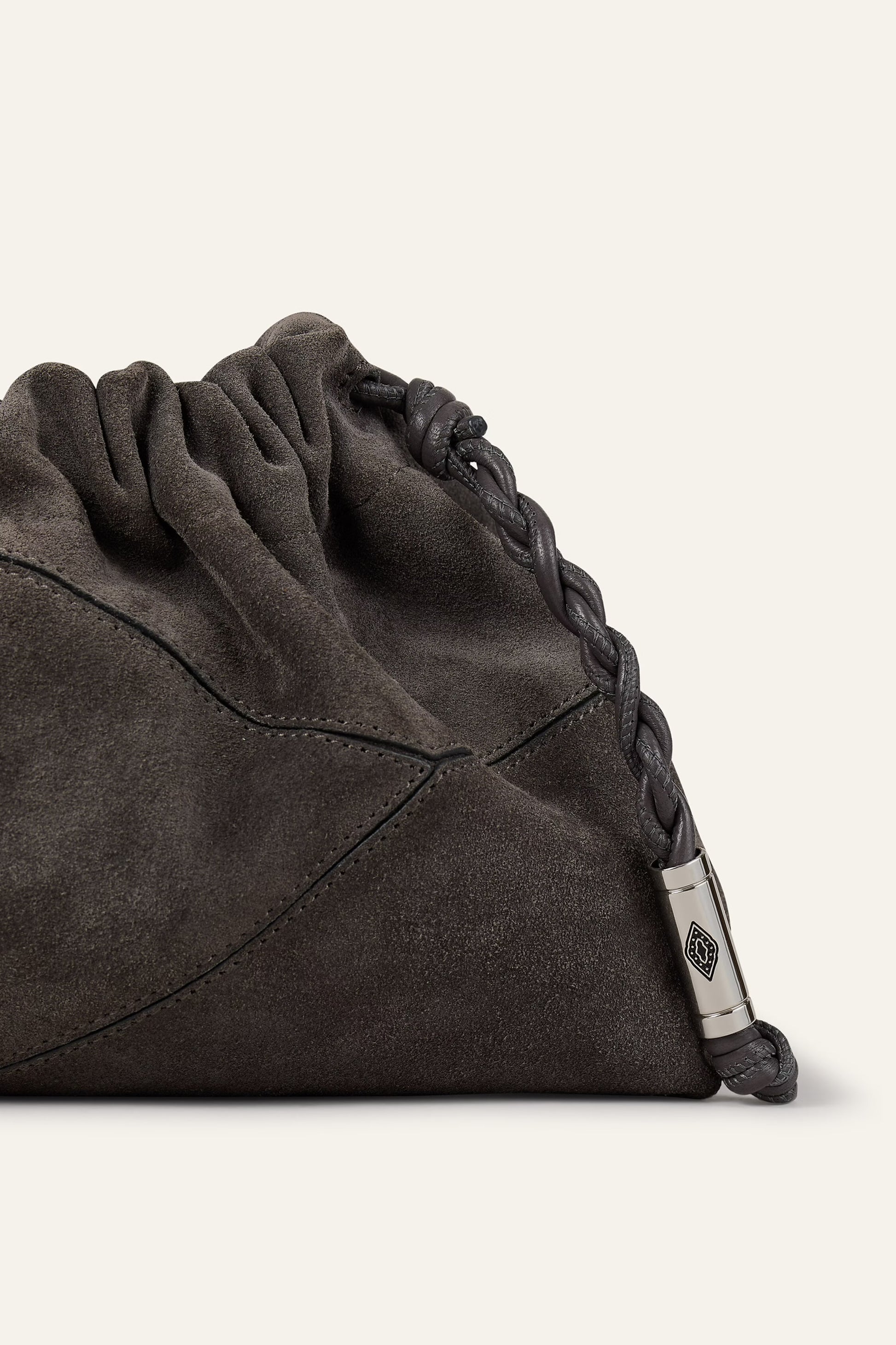 Dark gray drawstring bag with a metal tag on a light gray background from ba&sh