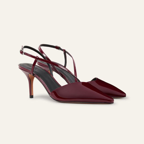 Pair of maroon high-heeled shoes on a light beige background