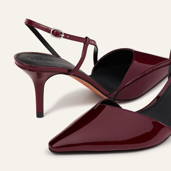 Maroon high-heeled shoes with a slingback design on a white background
