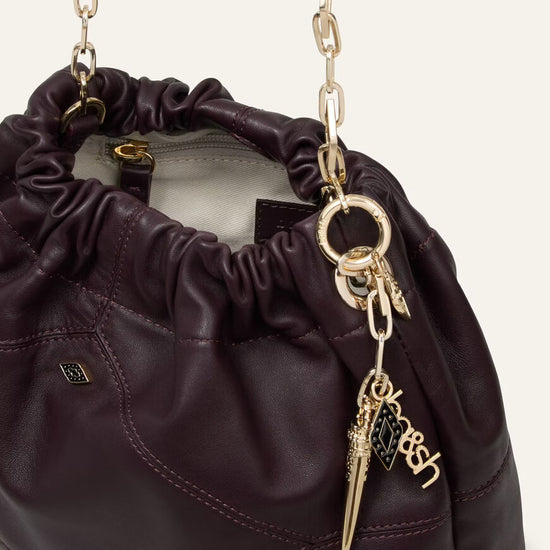 small burgundy leather scrunched bucket with gold chain strap and bag charm from ba&sh interior shot
