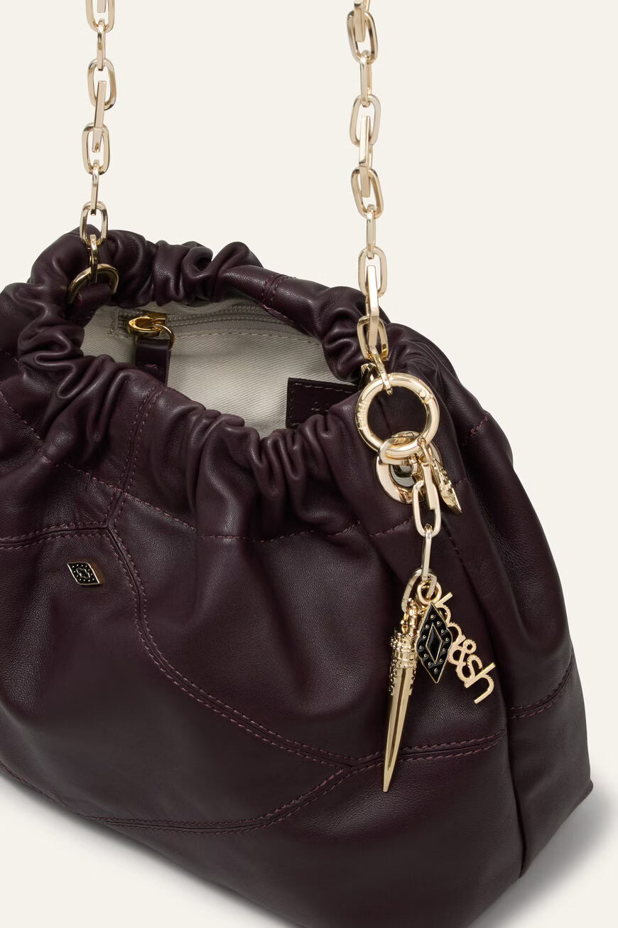 small burgundy leather scrunched bucket with gold chain strap and bag charm from ba&sh interior shot