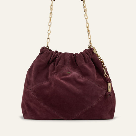 Burgundy suede bag on white background