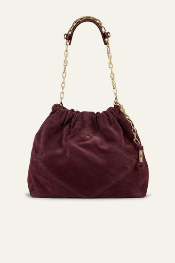Burgundy suede bag on white background