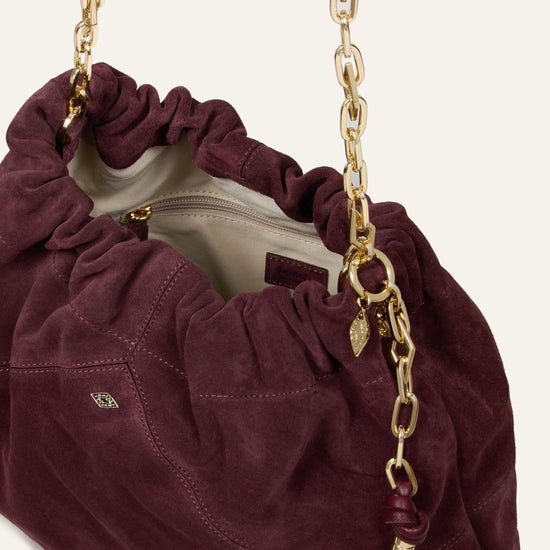 Burgundy suede bag on white background close up