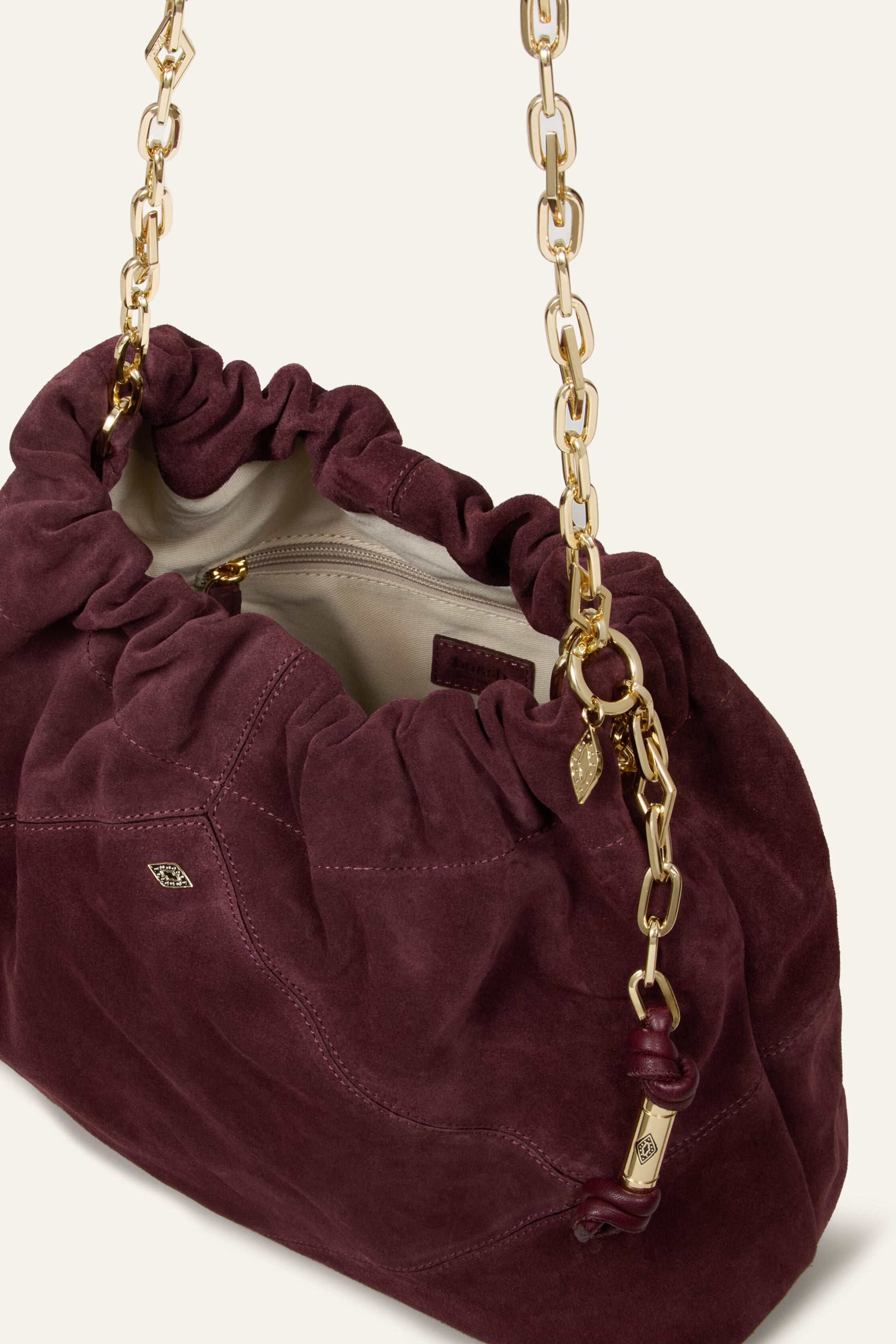 Burgundy suede bag on white background close up
