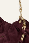 Burgundy suede bag on white background close up of chain