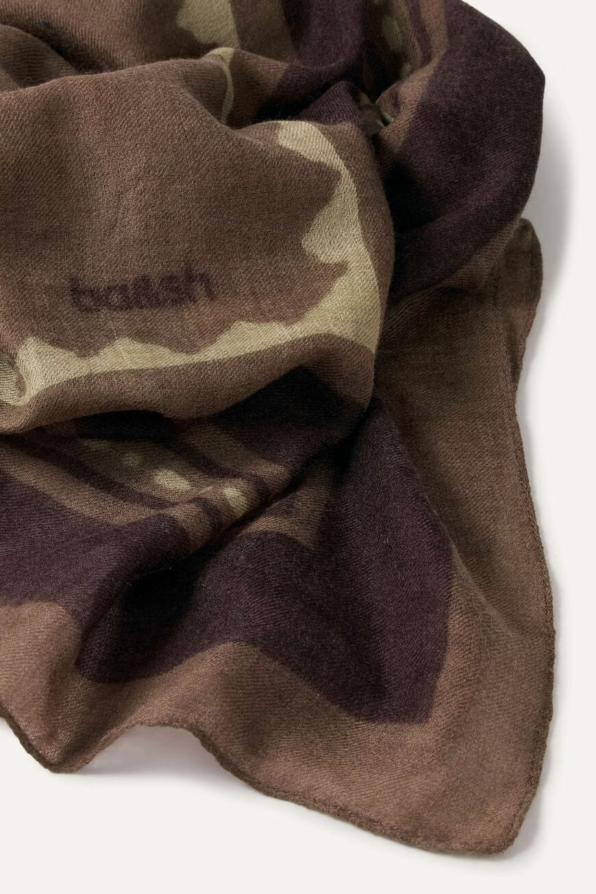 A close-up of a draped scarf in a brown, beige, and dark plum camouflage pattern, featuring the embroidered brand name 'balenciaga' on the left side.