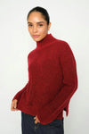 Woman wearing a red turtleneck sweater against a white background