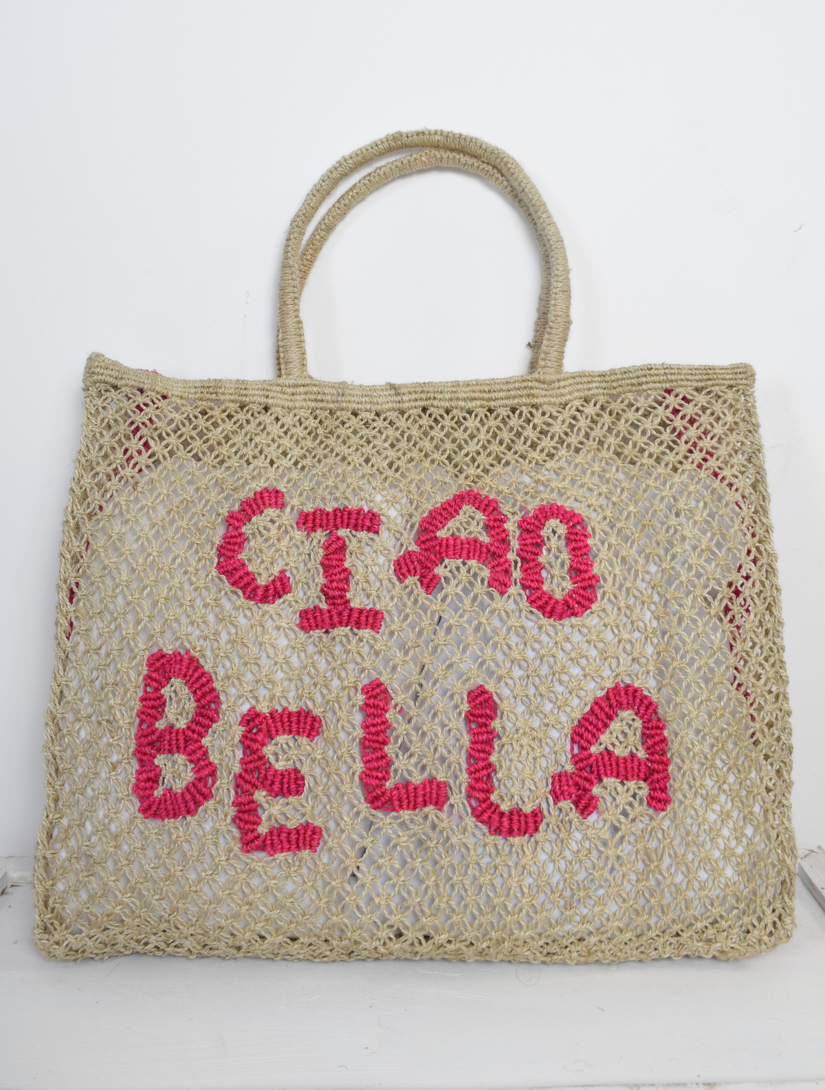 Woven Bag with pink writing saying Ciao Bella on the front 