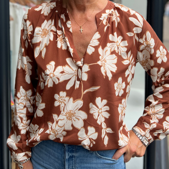 A tan top with white flowers 