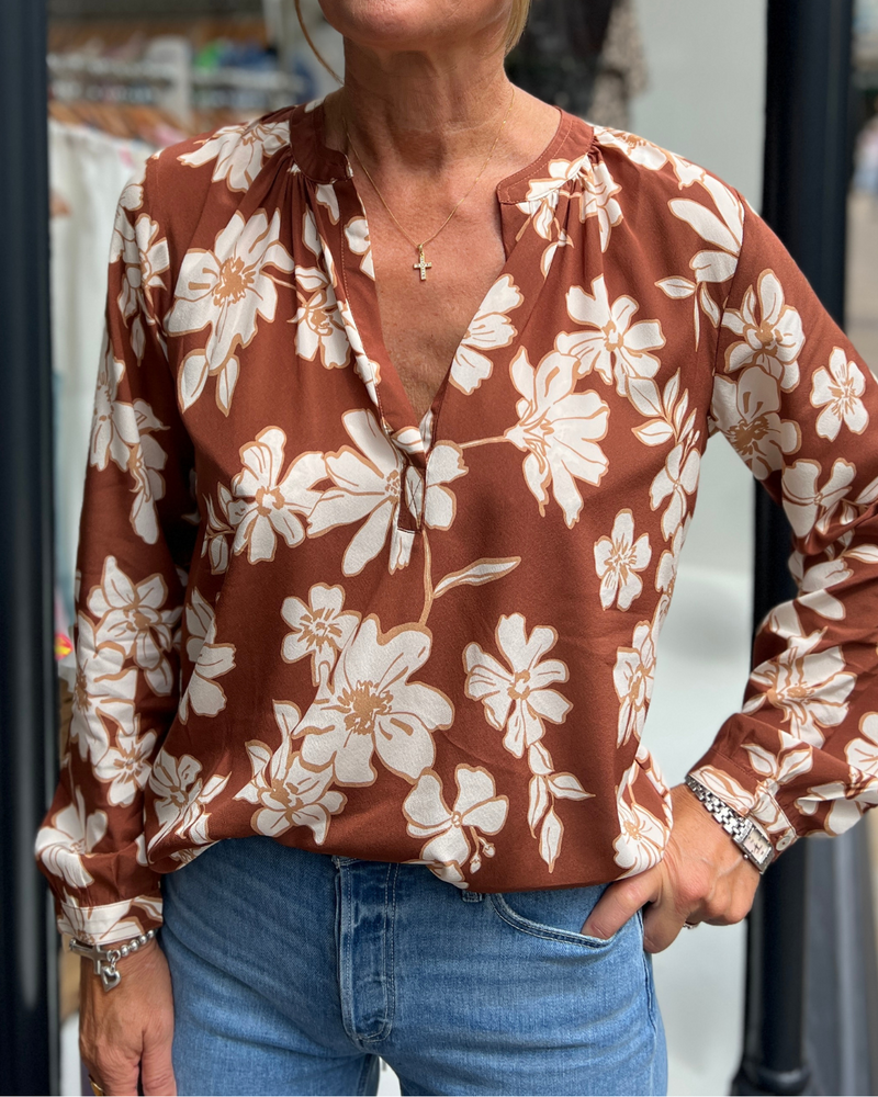 A tan top with white flowers 