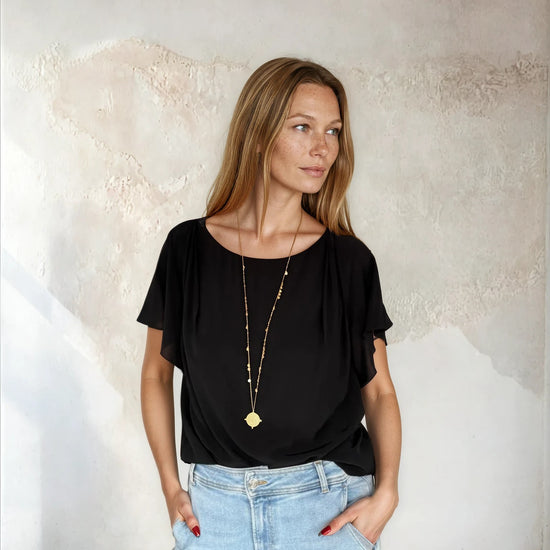 Black flutter sleeve top worn with blue denim