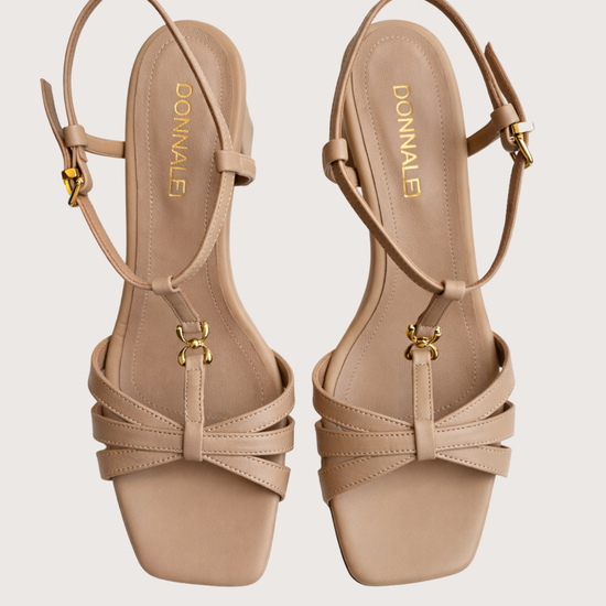 Pair of beige high-heeled on a light grey background