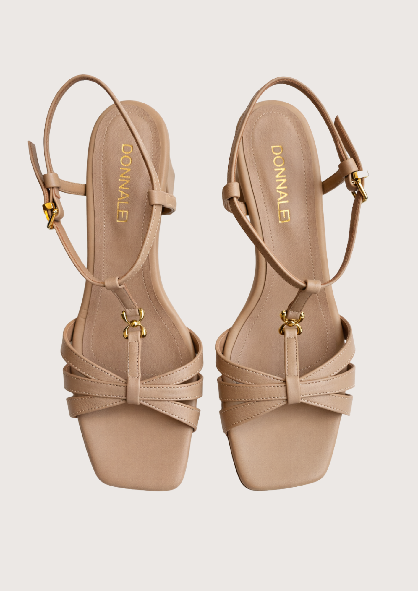 Pair of beige high-heeled on a light grey background