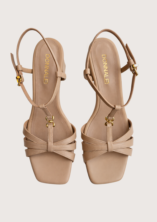 Pair of beige high-heeled on a light grey background