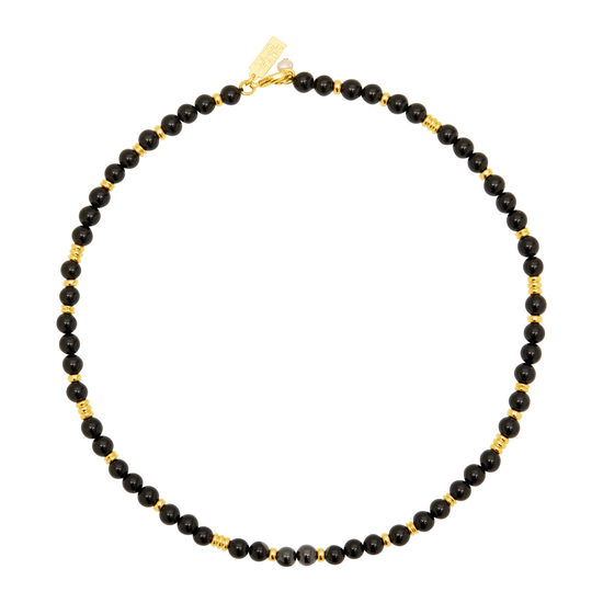 A beaded necklace featuring small, faceted black beads separated by tiny gold spacers, with a gold clasp, shown on a plain white background.