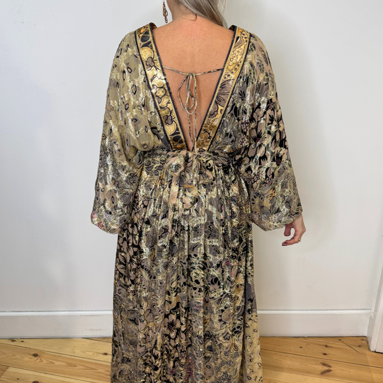 Gold patterned dress with low v-neck and long sleeves. Model shot