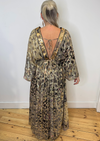 Gold patterned dress with low v-neck and long sleeves. Model shot