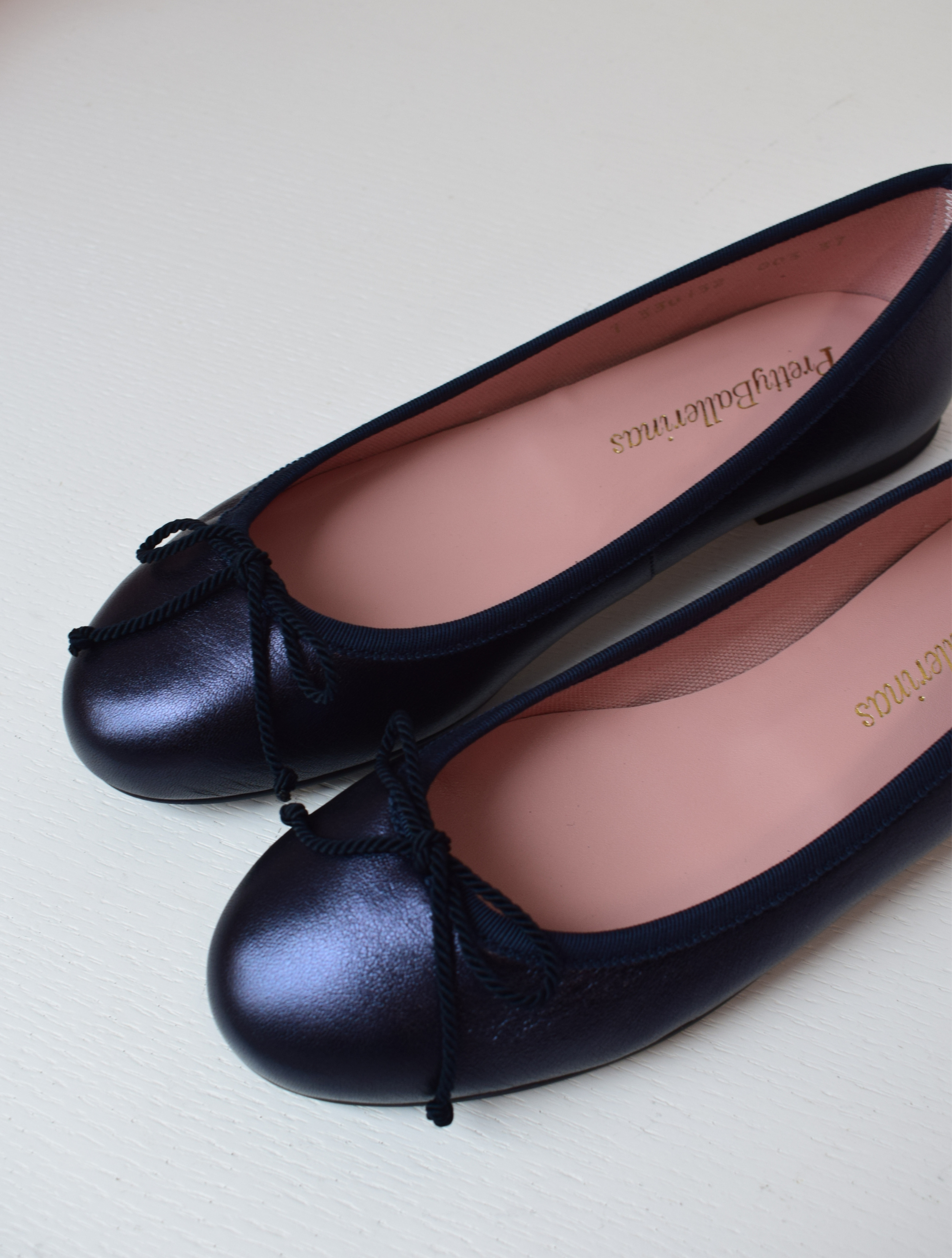 Shimmer navy blue classic round toe ballet pumps with navy thin ribbed binding and navy thin rope bow on toe