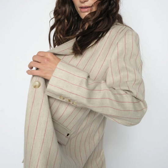 model wearing pinstripe blazer on plain background