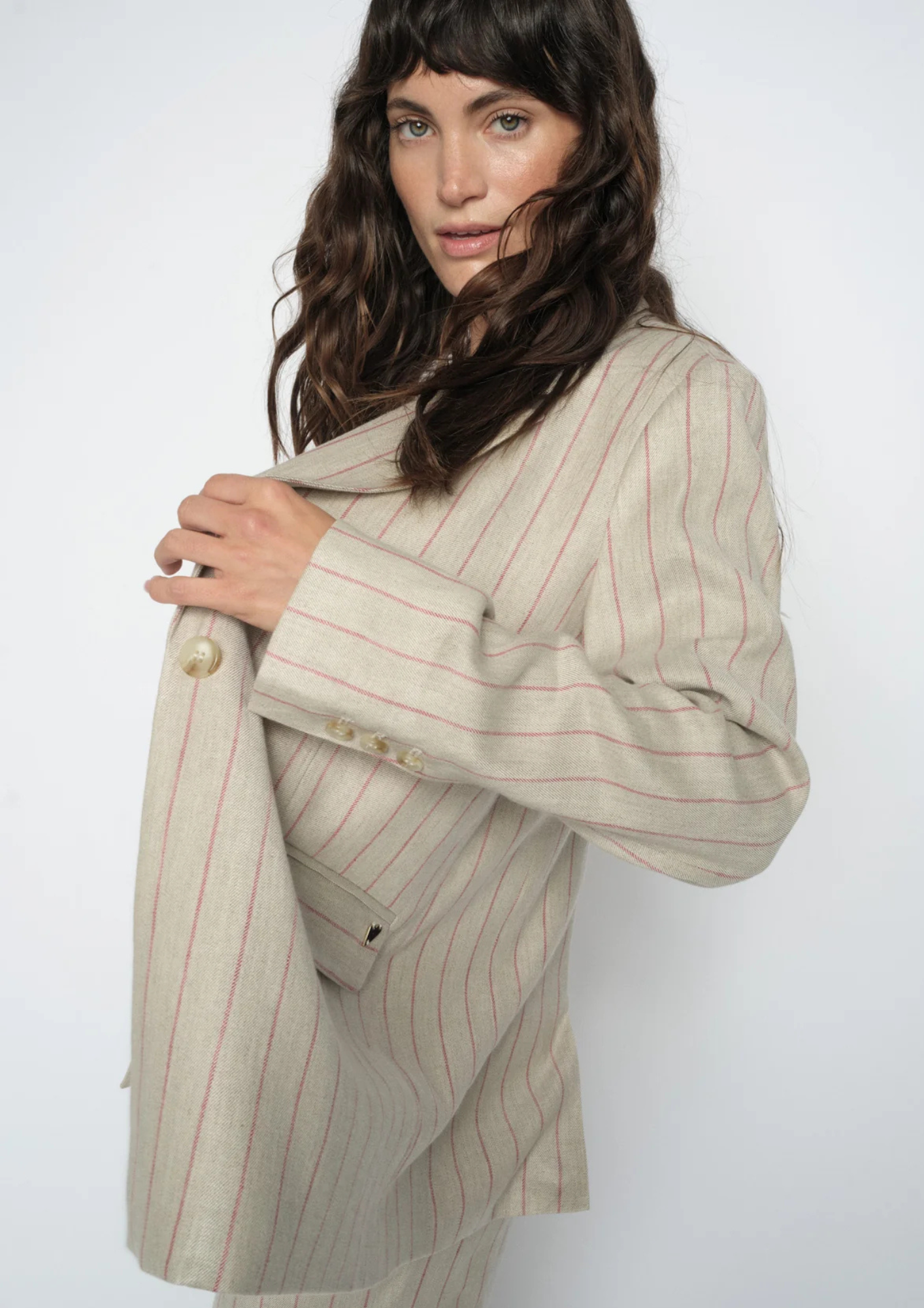 model wearing pinstripe blazer on plain background