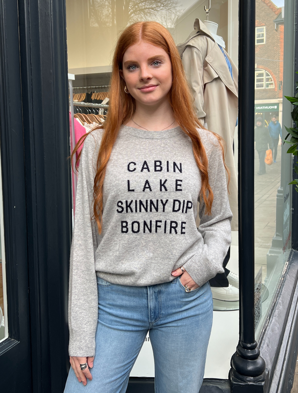grey cashmere jumper with cabin, lake, skinny dip and bonfire writen on it 
