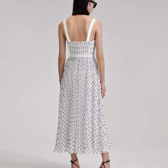 White and black polka dot midi dress with thin straps and fitted bodice with pleating throughout