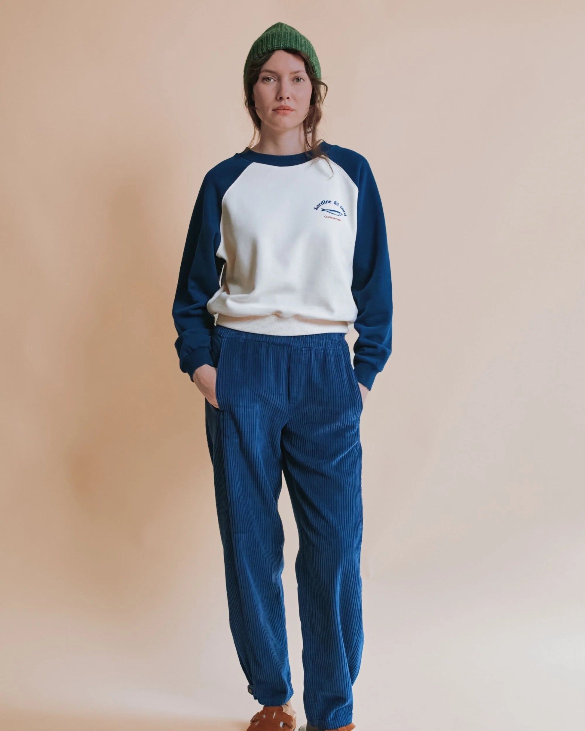 Woman wearing white and blue sweatshirt and blue trousers