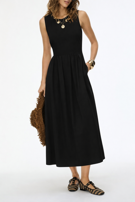 Woman wearing a black sleeveless dress holding a brown bag on a white background