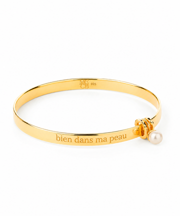 Gold bracelet with a pearl charm and engraved text on a white background