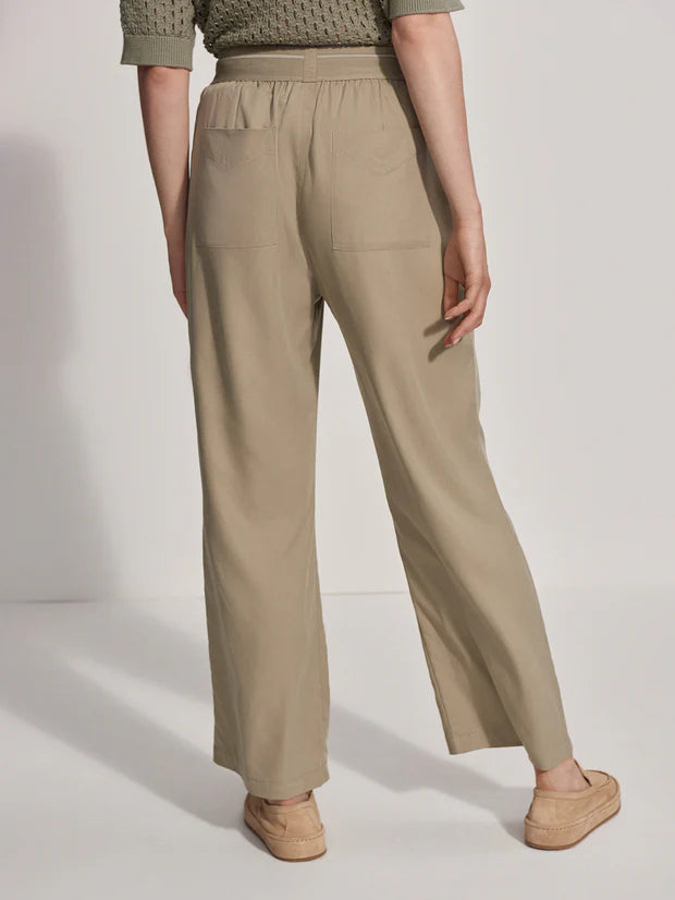 Model wearing relaxed fitting trousers in stone colour, rear view shows pockets