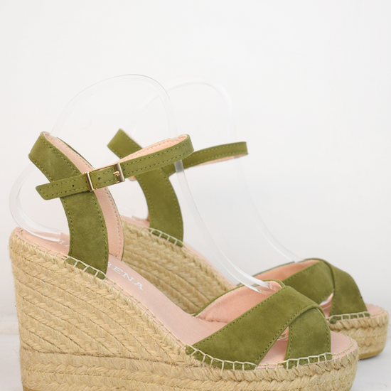 Wedge sandals with a green cross cover on the toes