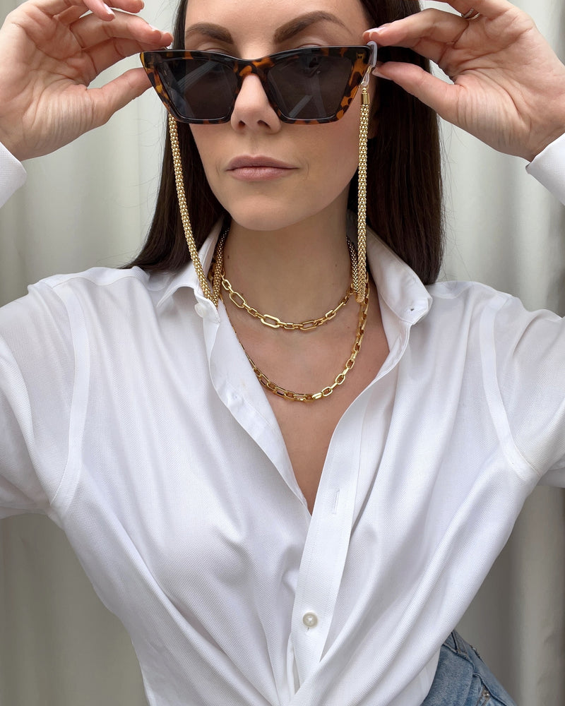 model shot of gold layered necklaces and sunglasses 