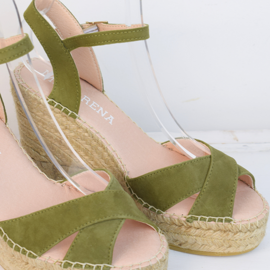 Wedge sandals with a green cross cover on the toes