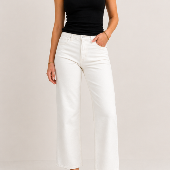 model wearing white jeans on plain background 