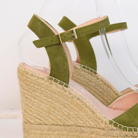 Wedge sandals with a green cross cover on the toes