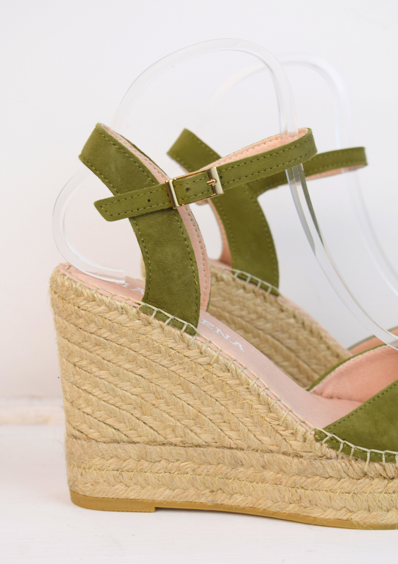 Wedge sandals with a green cross cover on the toes