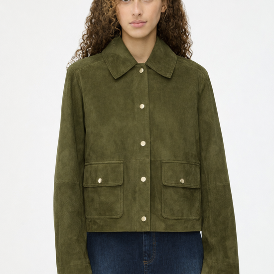 Woman wearing a green suede jacket on a white background
