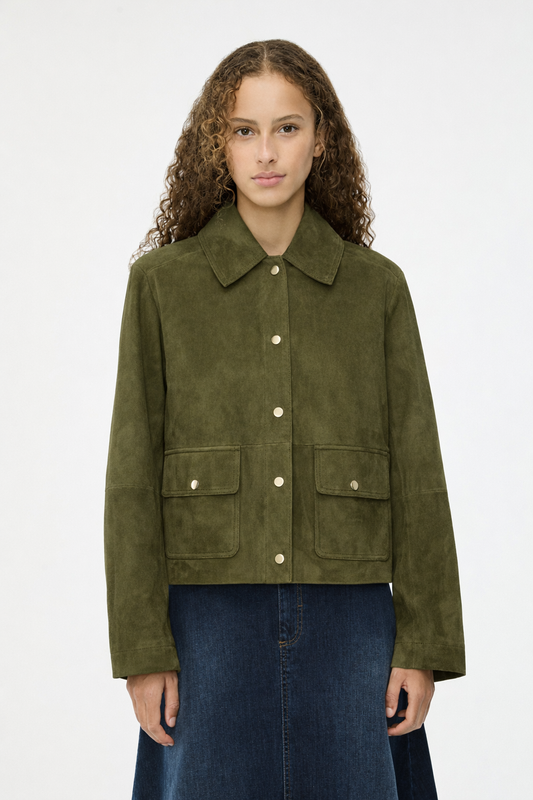 Woman wearing a green suede jacket on a white background