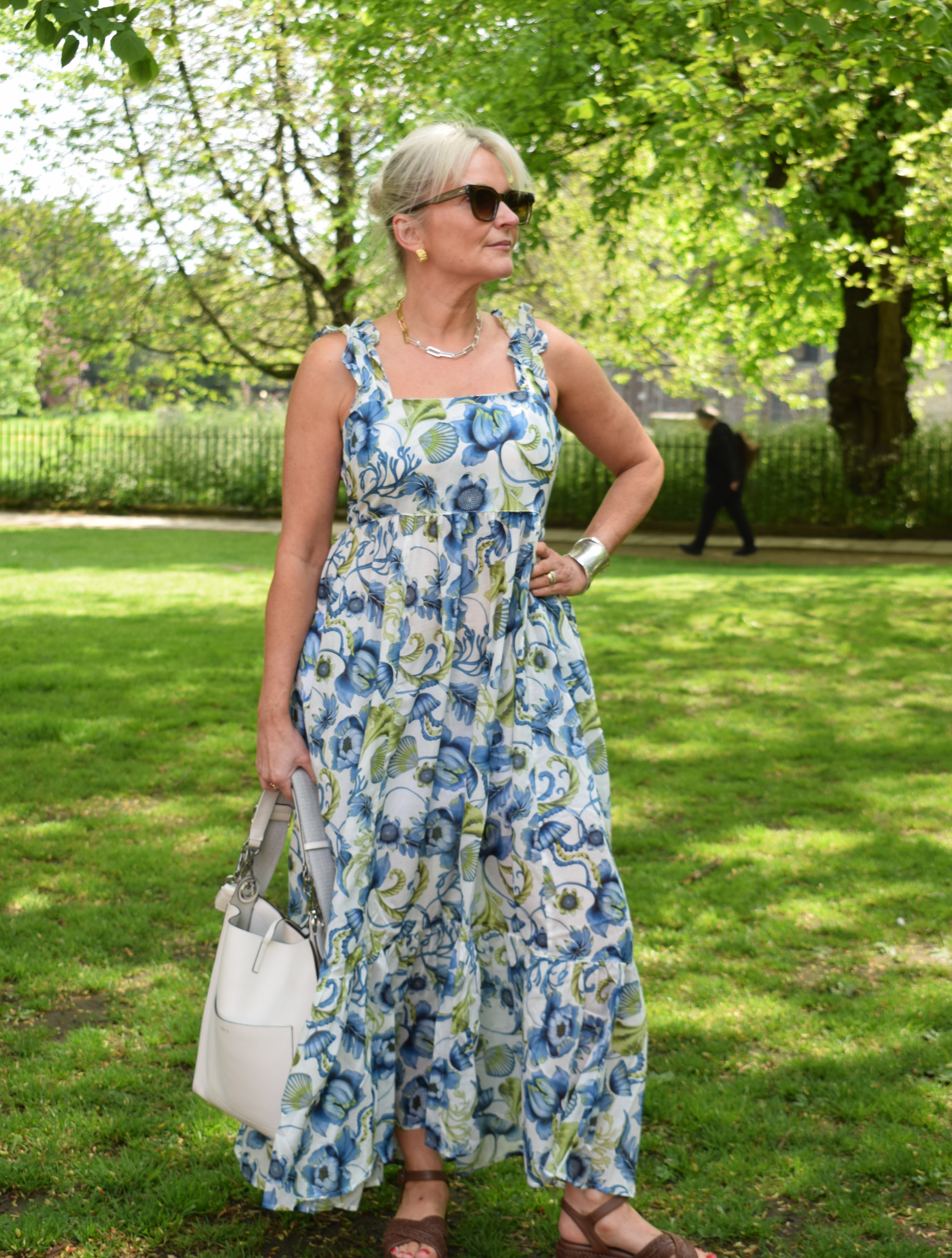 maxi floral dress with ecru base and blue and green pattern with ruffle straps tie back and deep frill