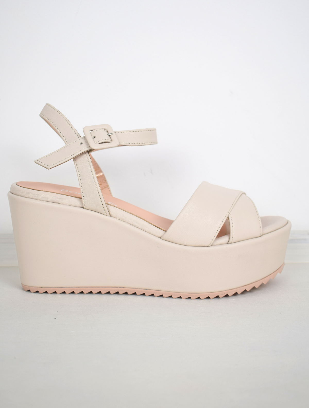 A flat pale pink sandal with large platform and ankle strap 
