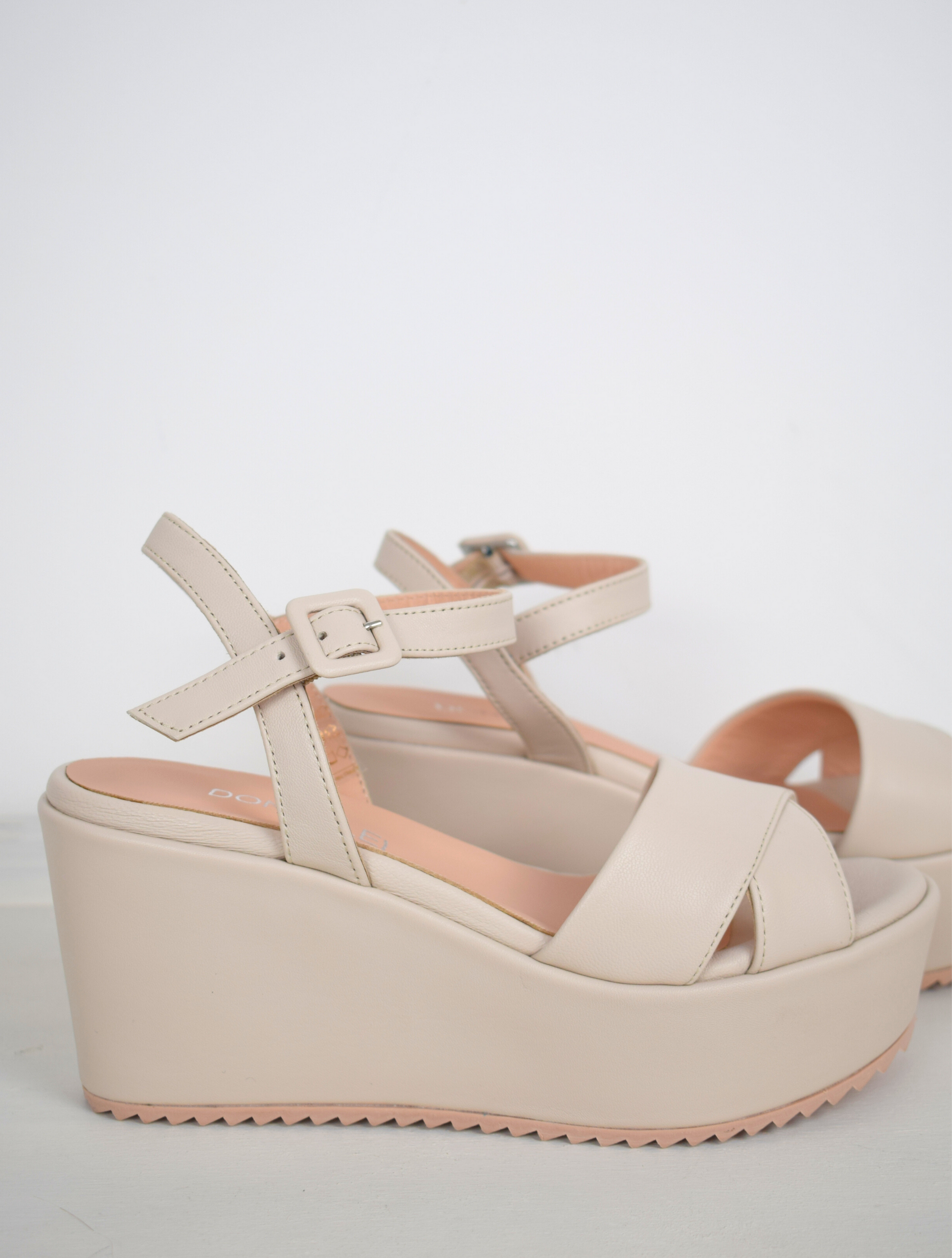 A flat pale pink sandal with large platform and ankle strap 