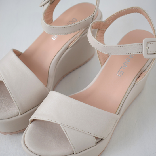 A flat pale pink sandal with large platform and ankle strap 