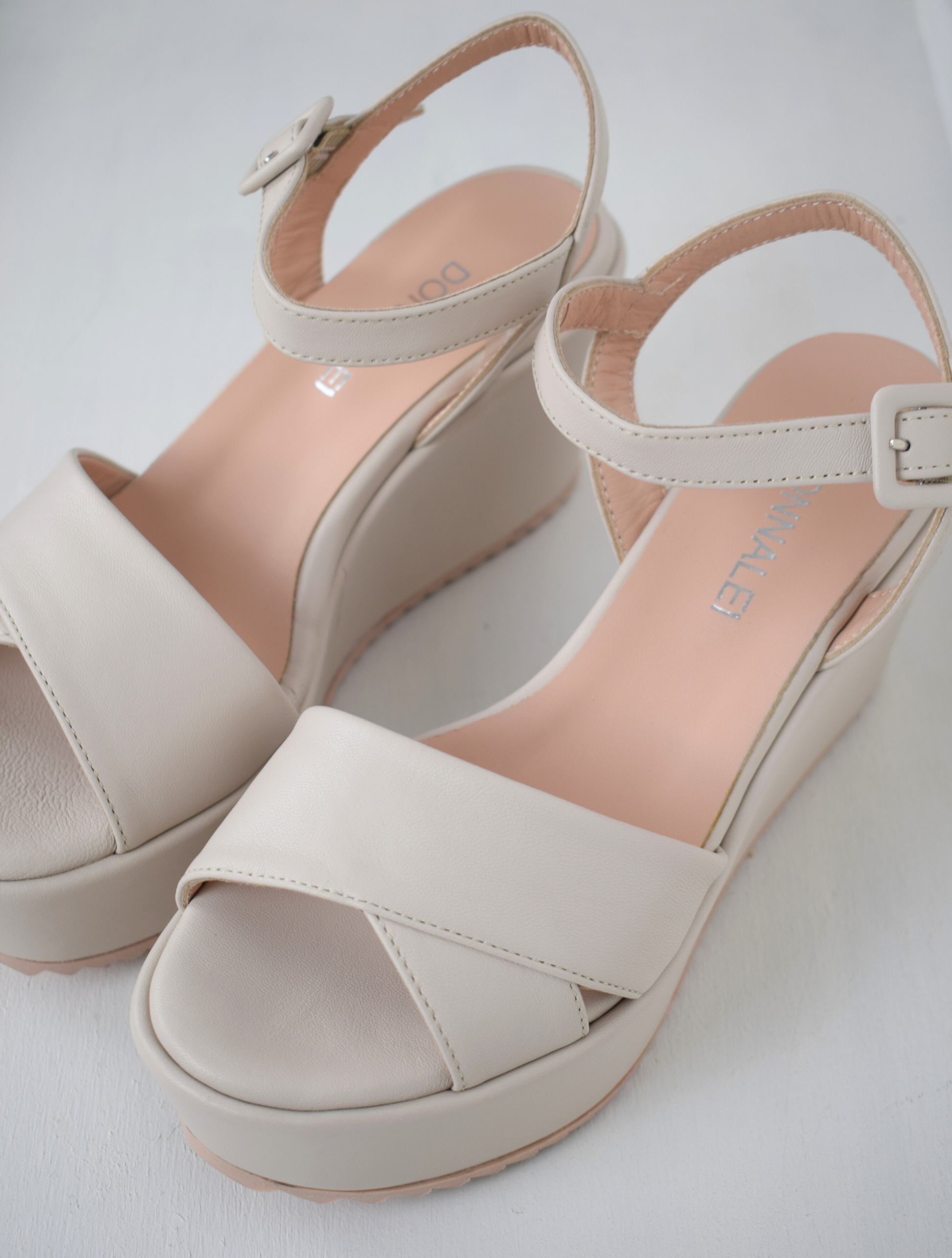 A flat pale pink sandal with large platform and ankle strap 