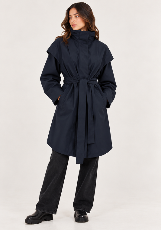 model shown wearing a navy coat with a tie at the waist on a plain white background